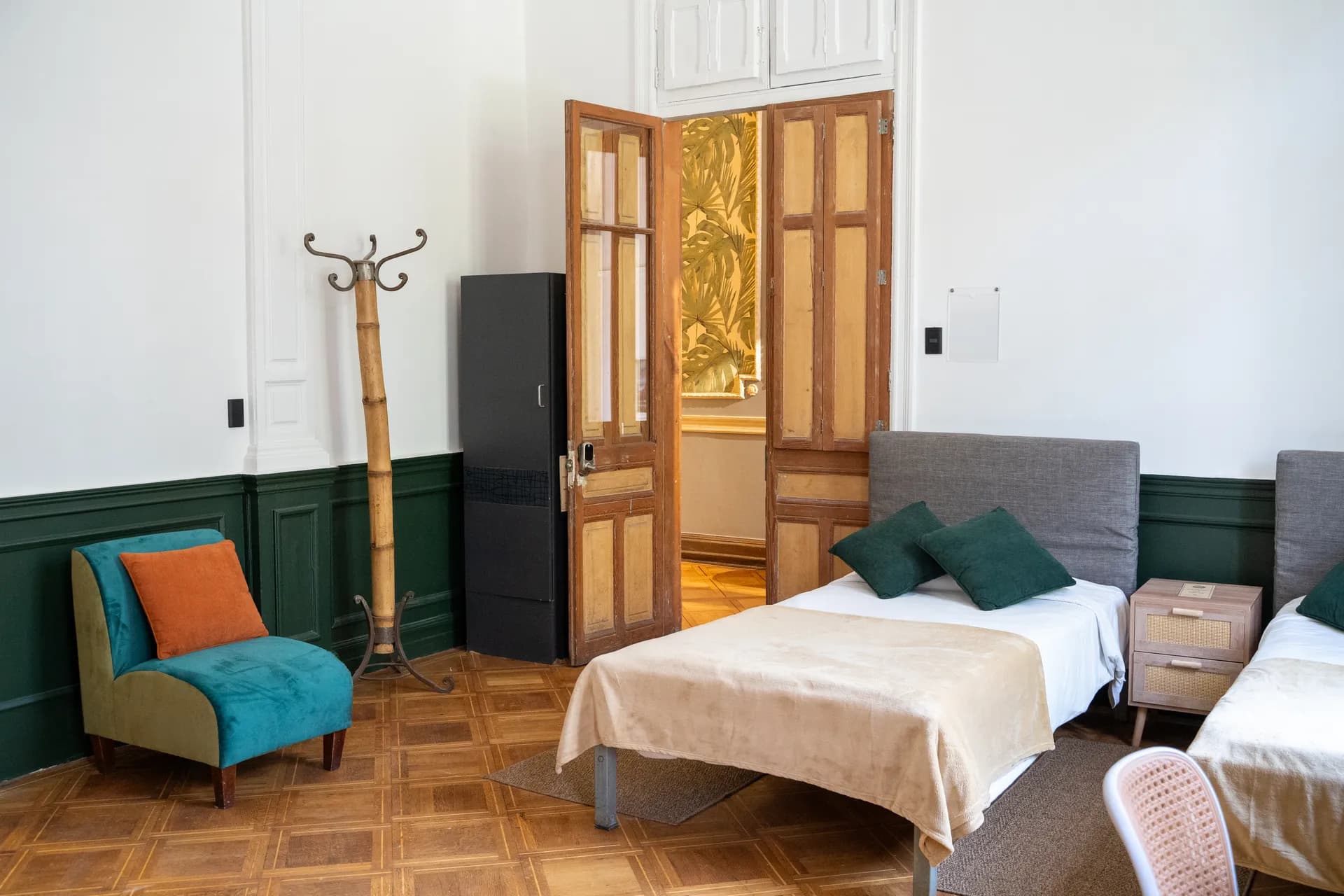 Grand deluxe quad room at Happy Hostel Santiago for 4 guests with original plaster ceiling rosette and checkered parquet floor